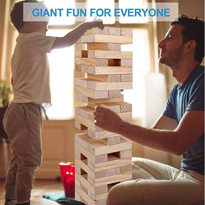 Dad and young boy playing giant jenga stacking game.